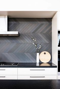 a kitchen with white cabinets and black counter tops, an oven and microwave are in the corner