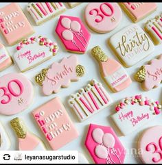 birthday cookies decorated with pink and gold icing on a white tablecloth that says happy 30th