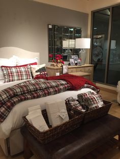 a bed with plaid sheets and pillows in a room