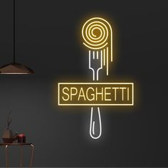 a neon sign that says spaghetti hanging from the ceiling next to a table with a lamp on it