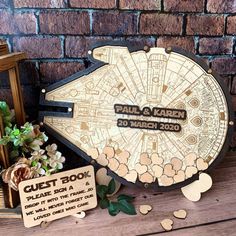 a star wars themed wedding guest book with wooden cutouts and flowers on a table