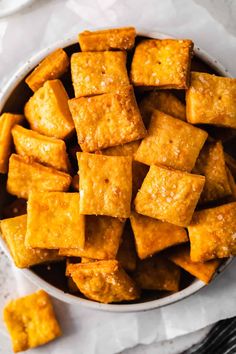 tofu cubes in a white bowl on top of a piece of parchment paper