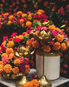 two vases filled with flowers sitting on top of a table