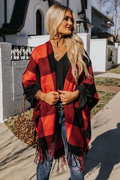 Our gorgeous 'Caramel Kisses' poncho is so easy to drape on and go with its lightweight material, large red and black buffalo check pattern, fringed trim detailing, open sides, and ultra draped silhouette that cascades into a straight mid-thigh length hemline! Oversized Fringe Cape For Fall, Fall Fringe Cape Outerwear, Fringe Cape Outerwear For Fall, Red Fringe Shawl For Fall, Red Fringed Shawl For Fall, Oversized Red Cape For Fall, Fall Red Shawl Cape, Red Shawl Cape For Fall, Casual Red Cape For Autumn