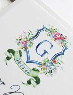 the letter q is surrounded by flowers and leaves on top of a white card that reads,