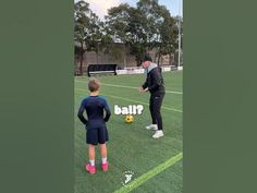 a man teaching a boy how to kick a soccer ball