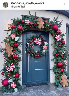 a christmas wreath with candy canes and gingerbreads hanging on the front door