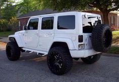 a white jeep parked in front of a house