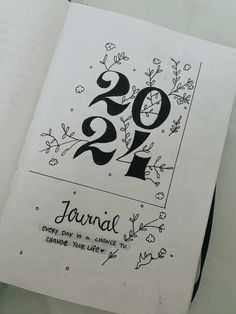 an open notebook with the number twenty two on it and floral designs in black ink