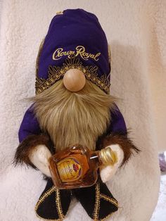 a stuffed animal wearing a purple hat and holding a bottle in it's hand