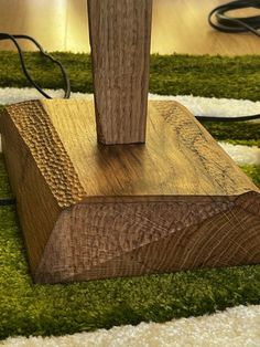 a wooden object sitting on top of a green carpeted floor next to a charger