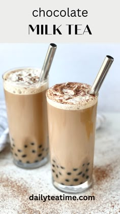 two glasses filled with chocolate milkshakes on top of a table