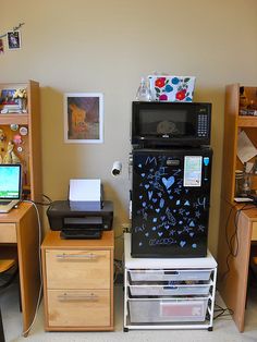 a room with two desks, a computer and a printer on top of it