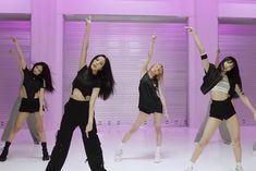 the girls are posing in front of purple doors and wearing all black outfits with their arms up