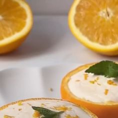 two oranges with cream and mint on them