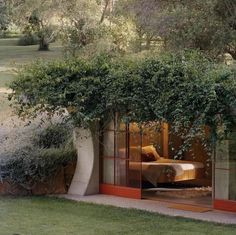 an outdoor bedroom with plants growing on the walls