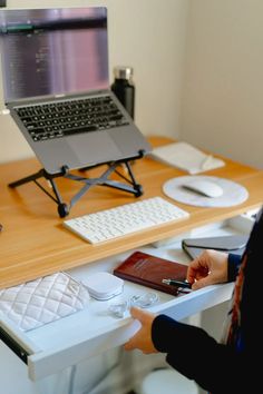 a person sitting at a desk with a laptop and cell phone in front of them