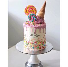 a birthday cake decorated with sprinkles and lollipops on top