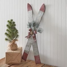 a pair of skis sitting on top of a wooden table next to a christmas tree