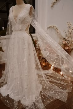 a white wedding dress on display in front of a mannequin's head