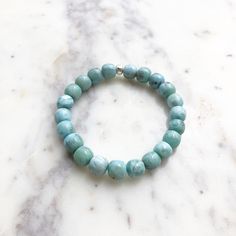 **Please note: all orders will not be shipped until after October 28th as I am currently away from the shop. Use the discount code OCTOBER to save CAD$7 off orders CAD$25 or more. Thank you for your patience! The last day to use the discount code is October 28th.** This beautiful, genuine Larimar stretch bracelet was handmade by me! It is made up of 8mm Larimar beads and an accent bead made of Karen Hill Tribe Silver (97%+ solid, fine Silver). I use a thick, 0.7mm stretch cord for the bracelets. Spiritual Stretch Bracelet With Round Amazonite Beads, Spiritual Stretch Bracelet With Amazonite Beads, Spiritual Amazonite Stretch Bracelet With Round Beads, Meditation Beaded Bracelets With Amazonite, Amazonite Beaded Bracelets For Meditation, Amazonite Beaded Bracelets For Everyday, Hand-strung Amazonite Beaded Bracelets, Everyday Blue Amazonite Bracelets, Everyday Hand-strung Turquoise Stretch Bracelet