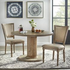 a round dining table with two chairs around it