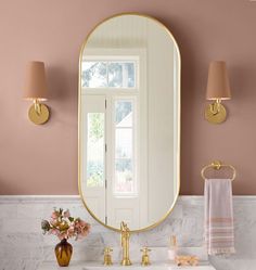 a bathroom with pink walls and gold fixtures