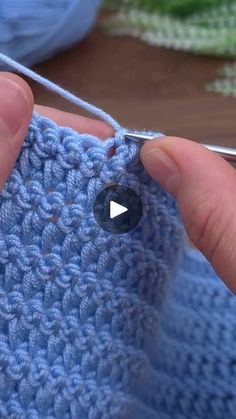 someone is crocheting the stitchs on their blue sweater