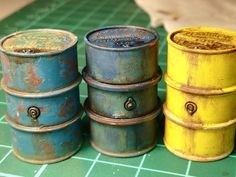 four old tin canisters sitting on top of a green counter