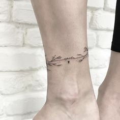 a woman's foot with a small tattoo on it