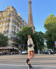 a woman standing in front of the eiffel tower with her hand on her hip