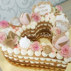 there is a cake that has been decorated with pink roses and other things on it