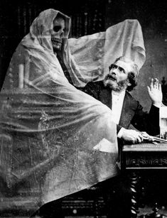 an old black and white photo of a man sitting in a chair with a ghost on his head