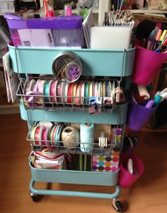 a blue cart filled with lots of different types of ribbons and other crafting supplies