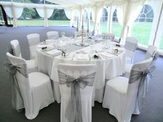 a banquet table set up with white linens and chairs