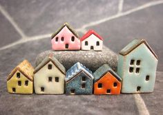 small ceramic houses sitting on top of a rock