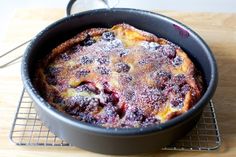 a cake in a pan with powdered sugar on top sitting on a cooling rack