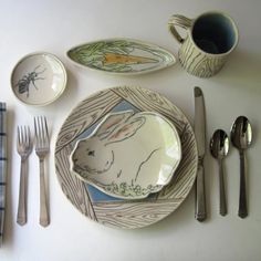 a white table topped with plates and silverware