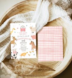 the pink and white baby shower is next to it's birth card on a wooden plate