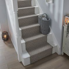 a set of stairs leading up to the second floor with baskets on each handrail