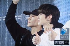 two young men giving the peace sign with their hands in front of an advertisement for water