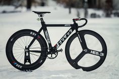 a bike is parked in the snow with its wheels still on it's rims