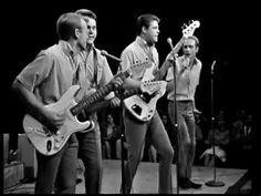 three men are playing guitars on stage