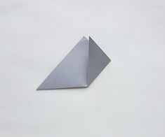 an origami shaped object sitting on top of a white surface