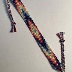 a multicolored beaded tie with tassels on a white table top