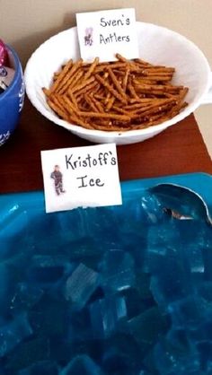 two bowls filled with ice and some kind of food on top of a wooden table