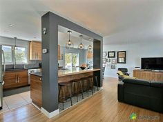 an open kitchen and living room with wood flooring