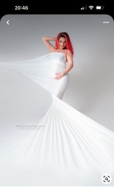 a woman with red hair is wearing a white dress and posing for a photo shoot