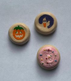 three decorated cookies with frosting and sprinkles are shown on a table