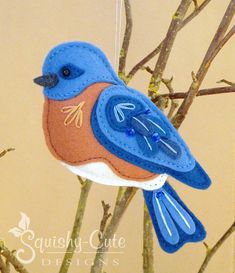 a blue bird ornament hanging from a tree branch